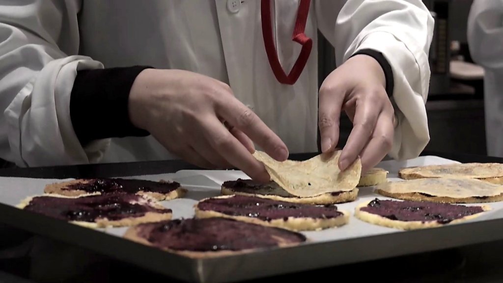 Pastry chefs laying wafers over berry rounds