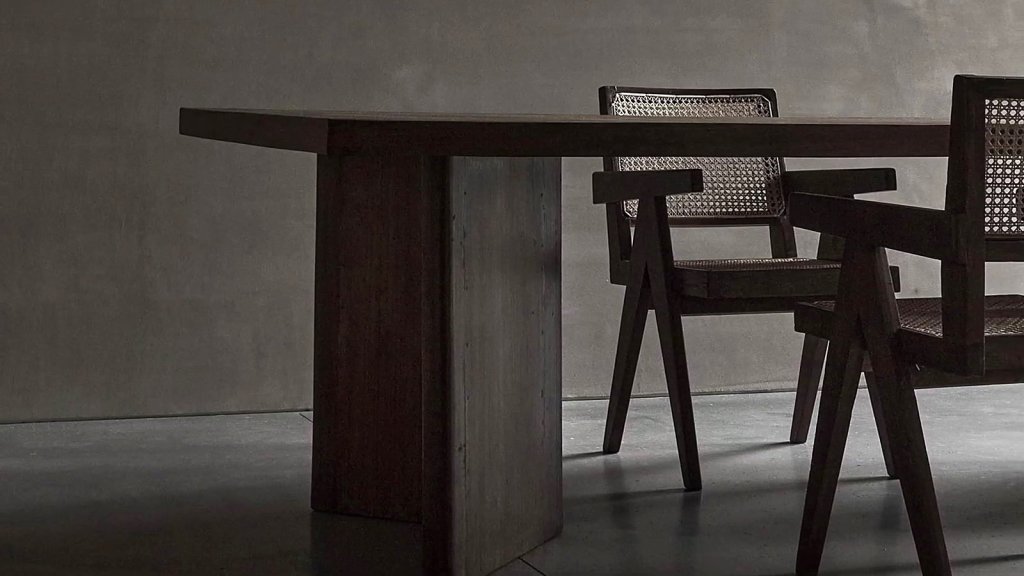 Dark timber table and cane chairs in a grey room