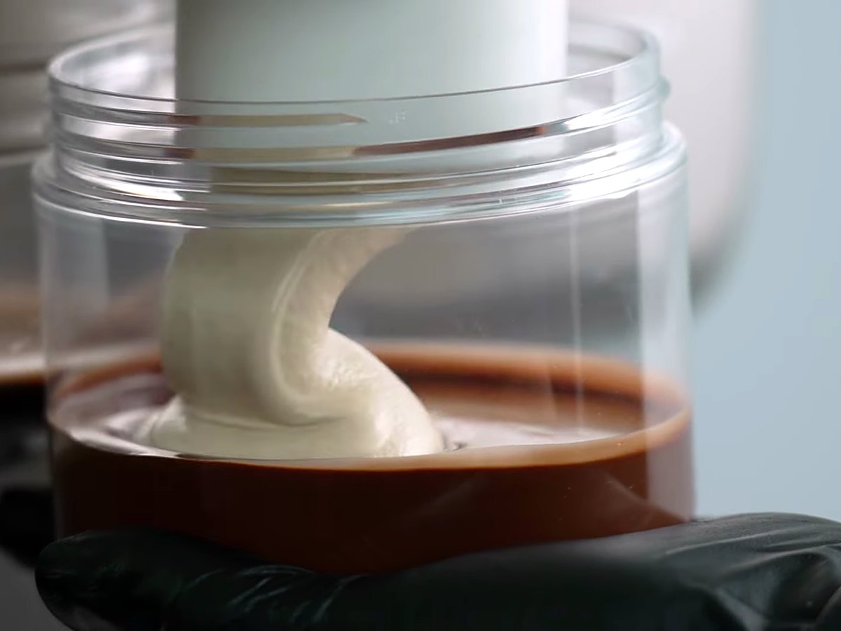 Gelato piped over a chocolate layer in a glass jar.