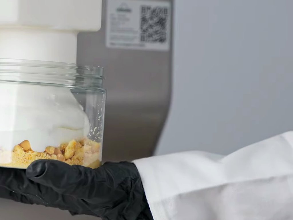 Gelato filling a glass jar over a biscuit crumb base