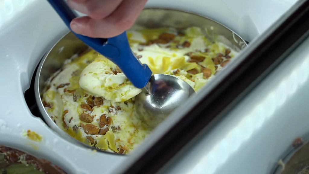 Fior di latte gelato with pistachio praline being scooped