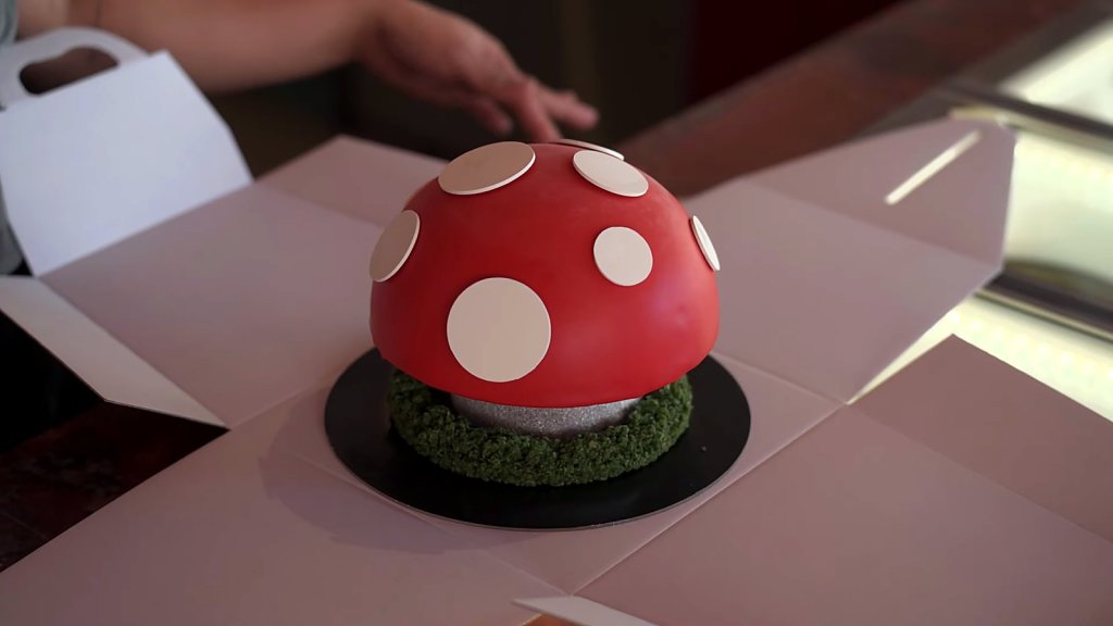 Red and white toadstool gelato cake on a mossy base