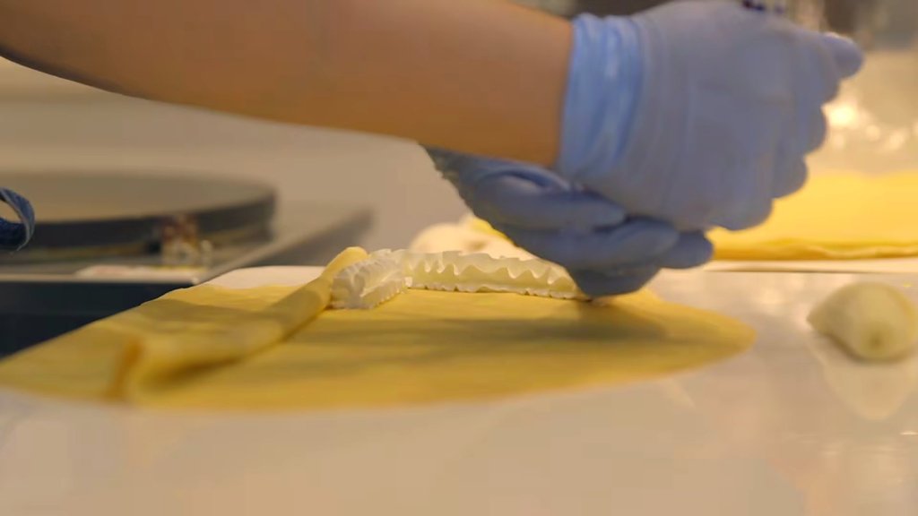Gloved hands making a crepe