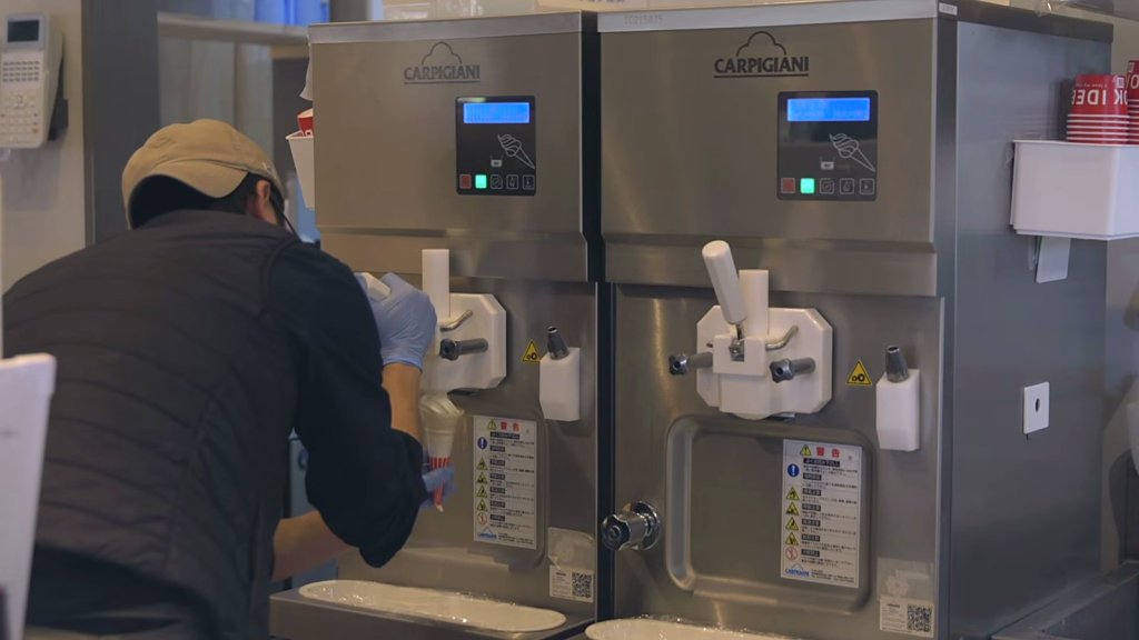 Staff member at two Carpigiani soft serve machines