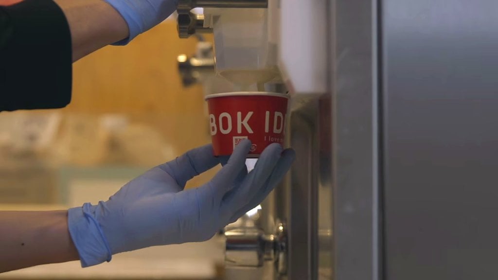 IDEBOK cup filled under a soft serve spout