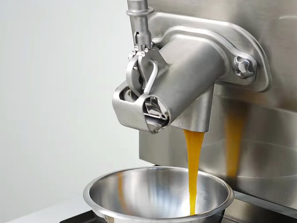 Amber caramel flowing from the tap into a bowl