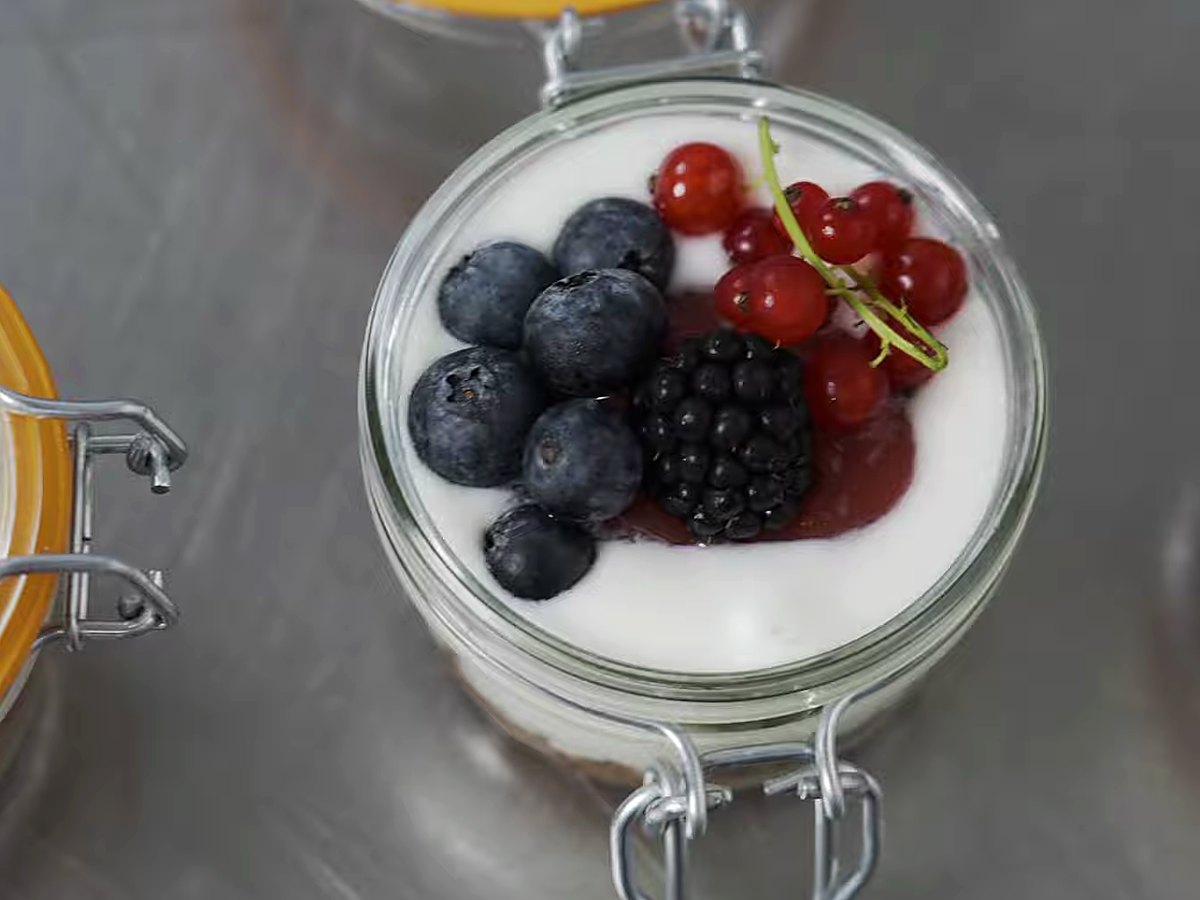 A layered jar dessert with fresh berries.