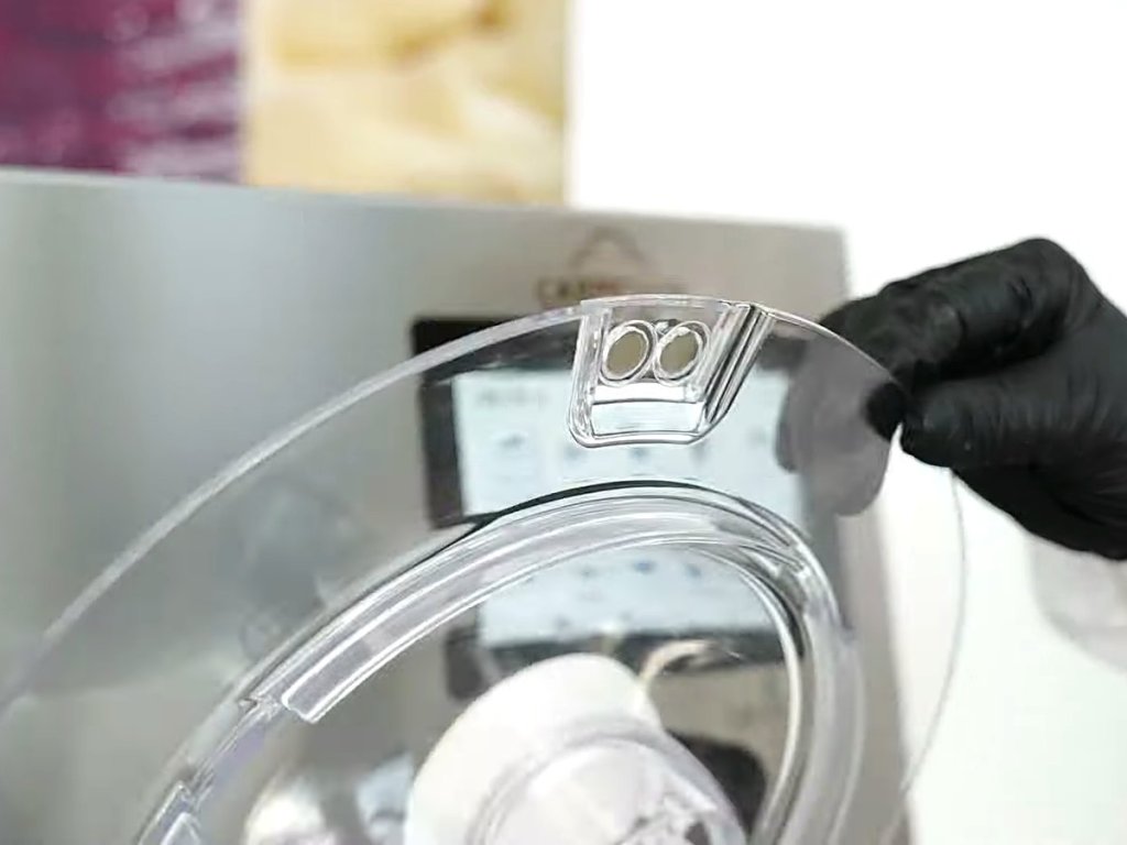 Gloved hand lifting the clear lid of the Lab-O-Chef 5
