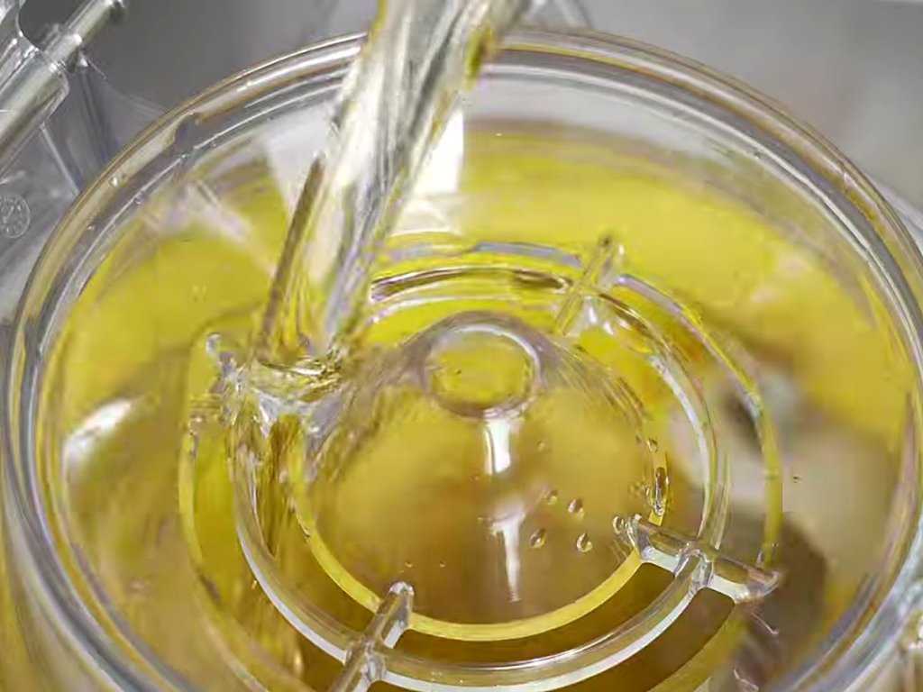 Golden liquid poured through the opening in the double lid